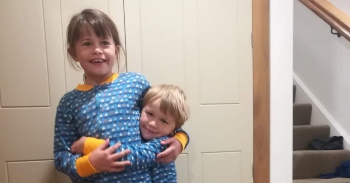 Two siblings standing together looking happy