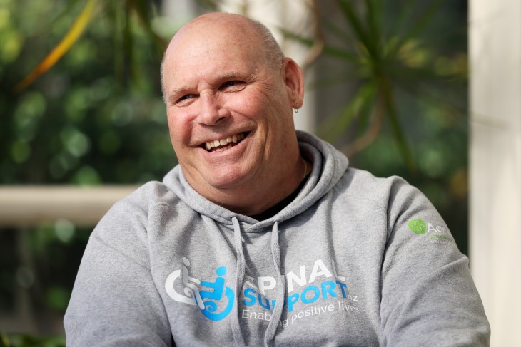 Brendan in a grey hoodie, smiling.