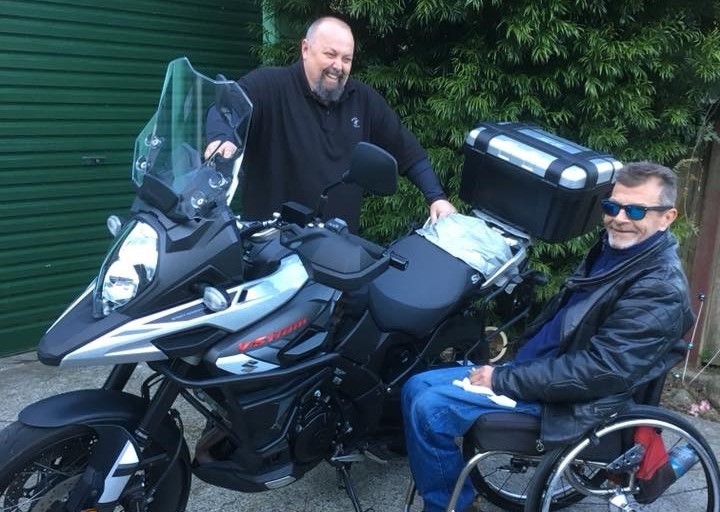 Dave and Jason laugh by Dave's bike