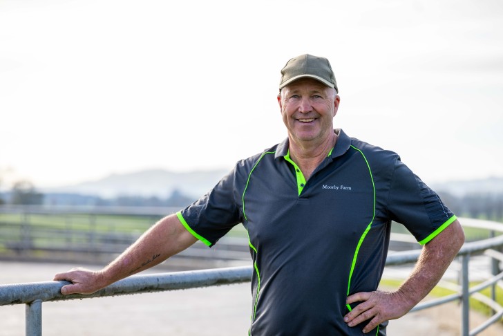 A close-up photo of John Moorby leaning on a fence on his farm.
