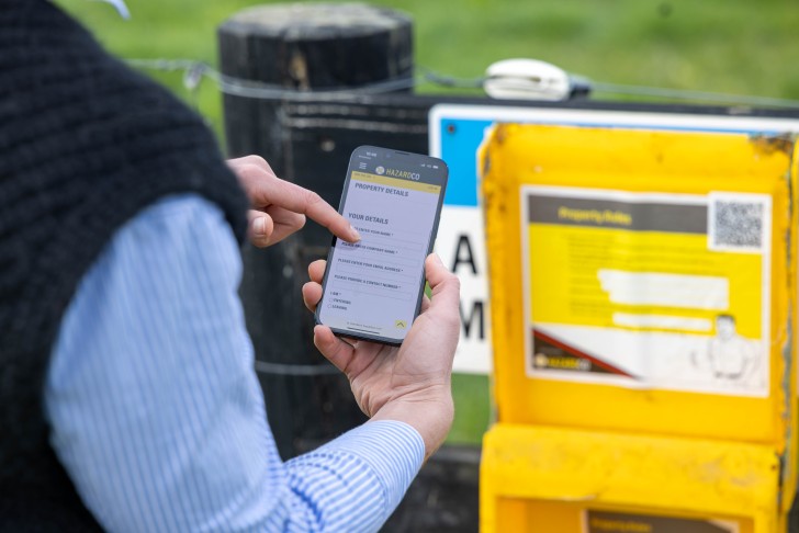 A person looking at their phone after scanning the information at the entrance to John Moorby's farm.