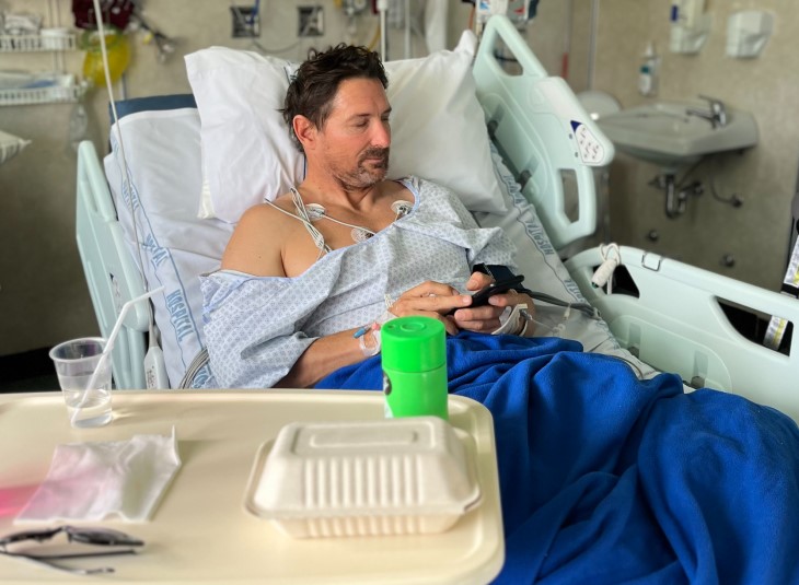 Maz Quinn lying in a hospital bed. 