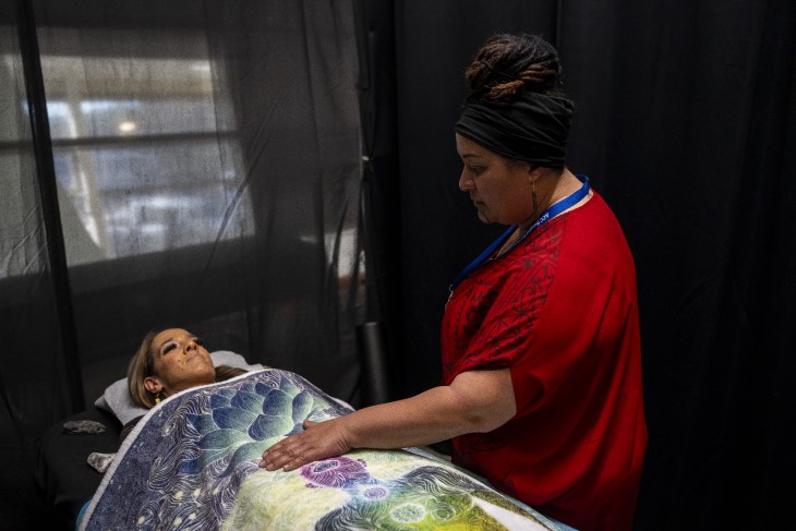 A rongoā Māori practitioner using her healing methods on a woman at the ACC Rongoā Māori Conference.