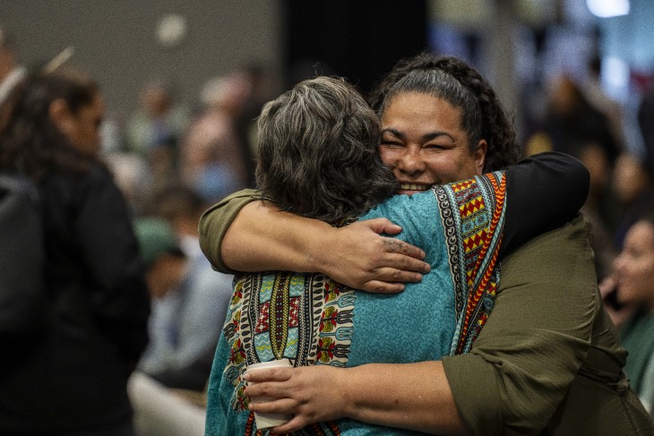 Two Māori women embracing each other at the ACC Rongoā Māori Conference.