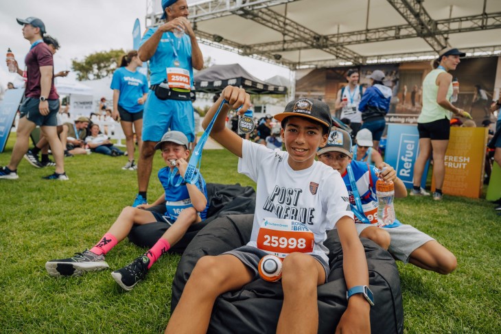 Several children showing off their medals after completing Round the Bays. 