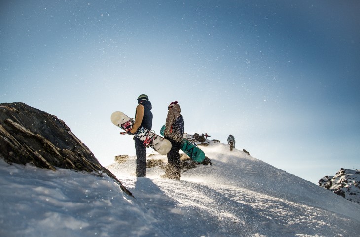 Two snowboarders standing on ski field 