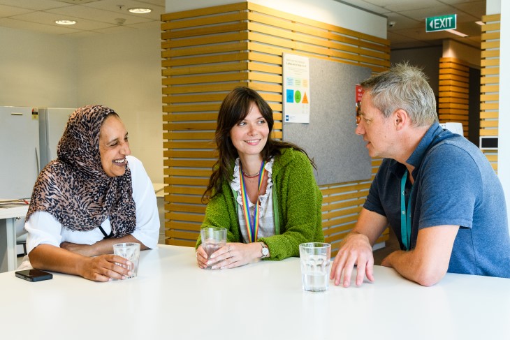 staff sitting around a table having a meeting