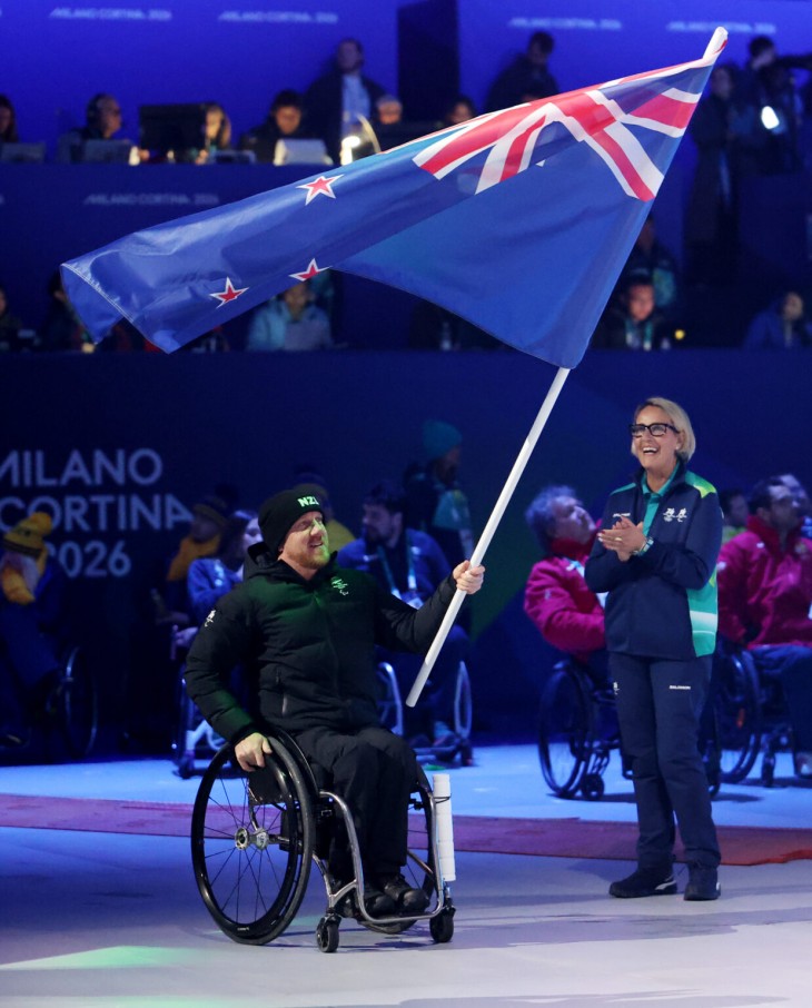Corey Peters acting as flagbearer for the New Zealand team at the Winter Paralympics closing ceremony.